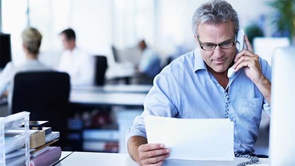 man-reading-paper-on-phone man-reading-paper-on-phone